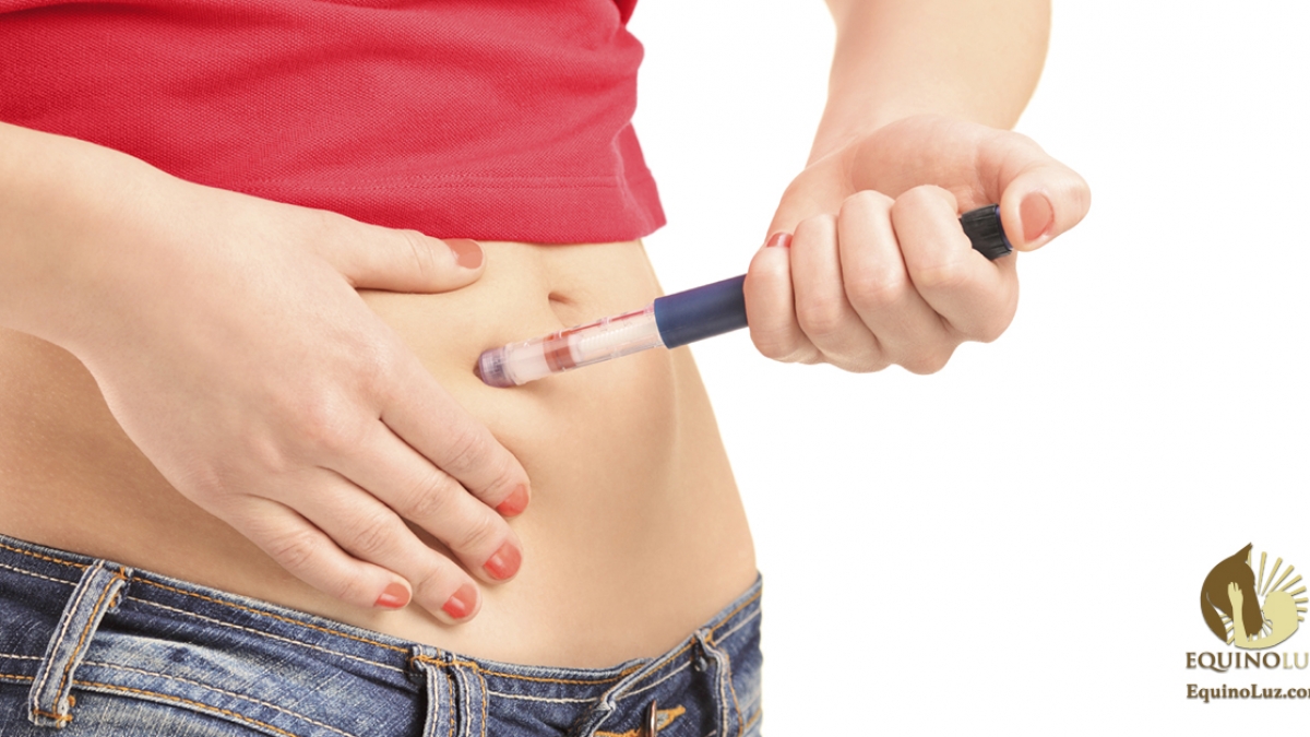 Young female injecting insulin in her abdomen isolated on white background